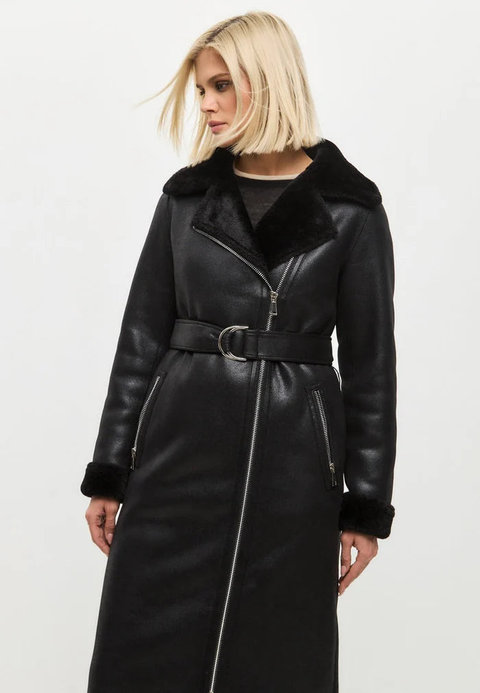 A stylish black shearling coat, a reversible long faux shearling jacket, ideal for women's winter outerwear, showcasing trendy shearling clothing.
