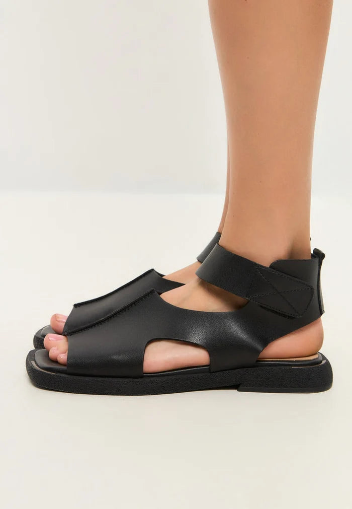 A fashionable pair of black leather ankle-strap sandals, perfect for adding a stylish touch to any outfit.