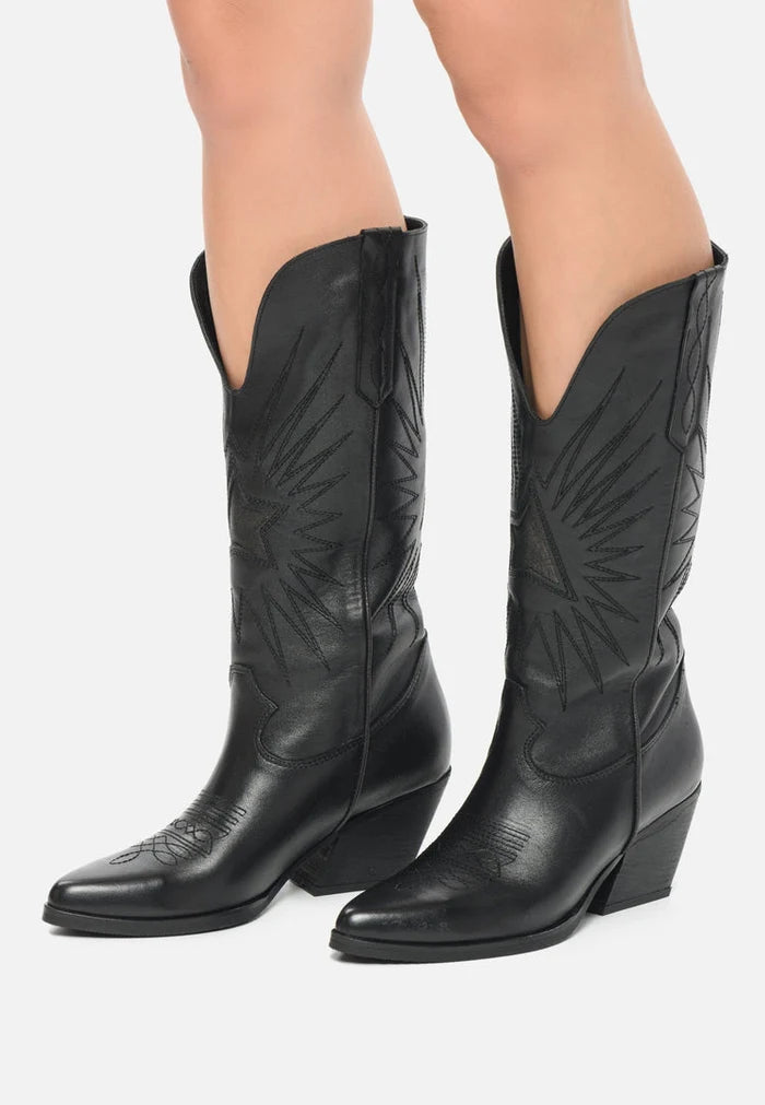 A pair of stylish black cowboy boots with a pointed toe, block heel, and intricate Western leather details.