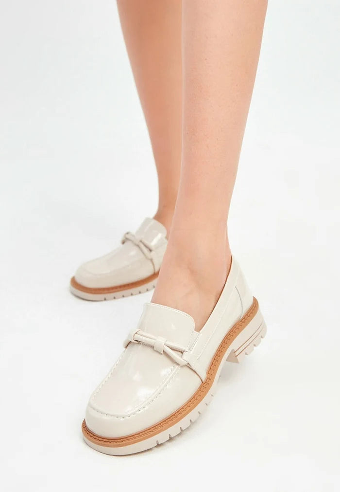 A stylish pair of beige block heels loafers for women, combining fashionable heels with comfortable loafers design.