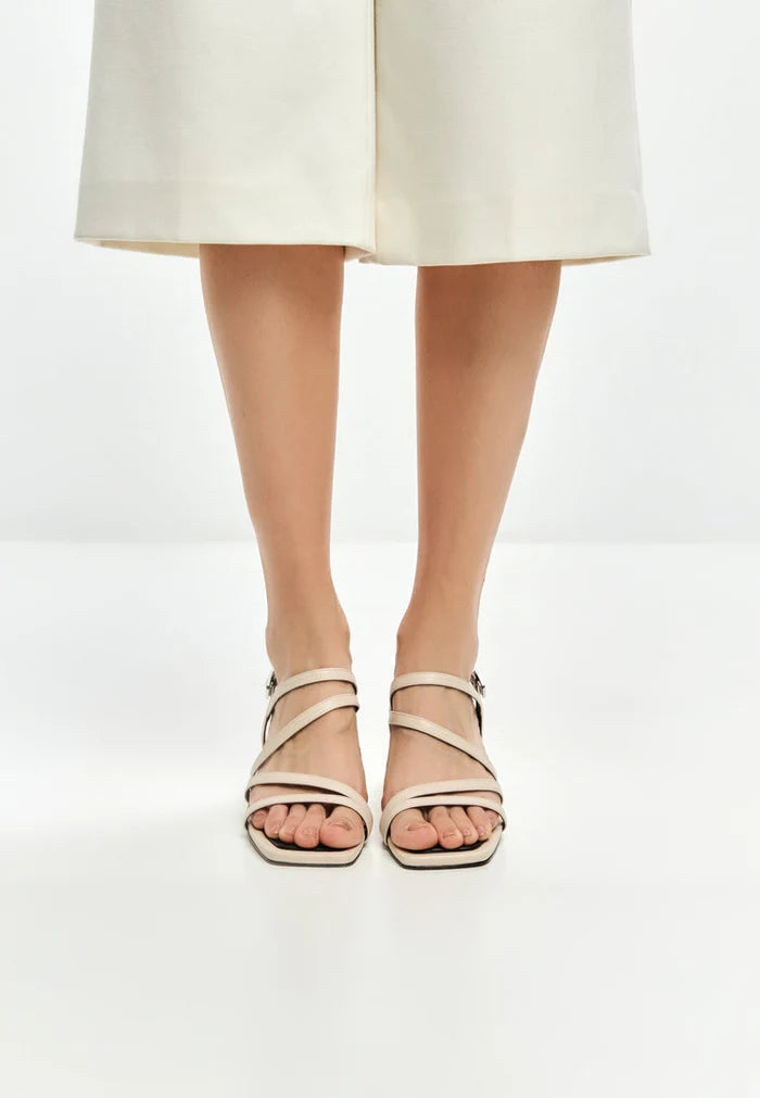 A stylish pair of block heel Maria sandals in beige, perfect for women looking for fashionable footwear.