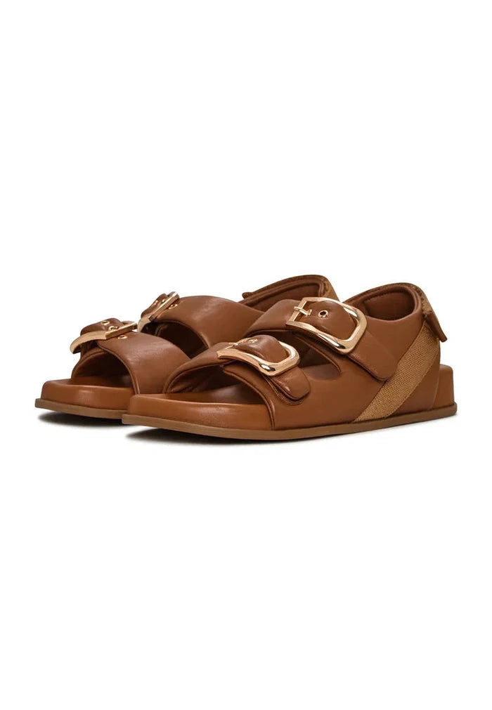 A pair of stylish beige women's wedge sandals with bold buckle details, perfect for summer footwear.