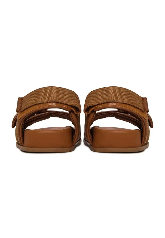 A stylish pair of beige women's wedge sandals featuring bold buckle detail, perfect for summer footwear.