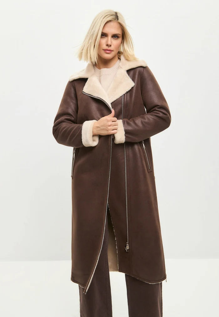 A stylish woman in a luxurious brown faux fur coat that can be reversed to reveal a cozy shearling lining, a versatile and trendy long shearling jacket perfect for winter, the ultimate brown faux fur outerwear that exudes elegance, and a must-have shearling coat for women.