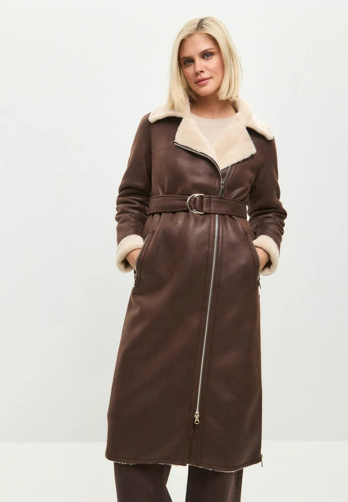 A stylish brown faux fur coat that can be reversed to reveal a cozy shearling lining, perfect for the fashionable woman looking for a long shearling jacket as her go-to outerwear choice.