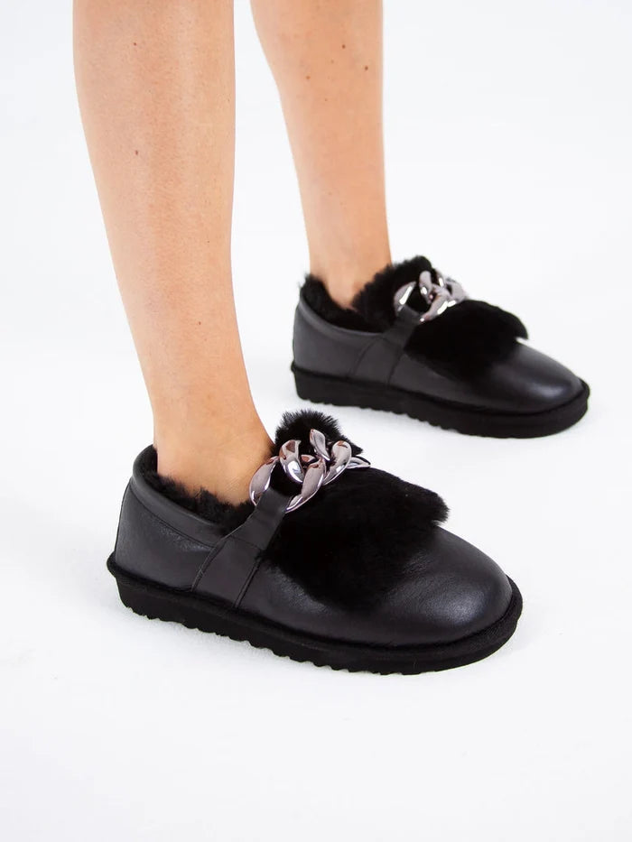 A pair of stylish black fur lined loafers with chain detail, ideal as women's winter shoes for a chic and casual look.