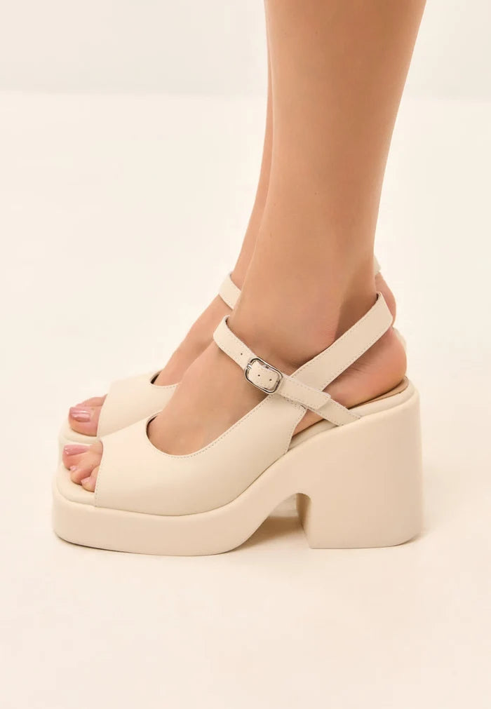 A pair of trendy chunky white platform sandals with a bold heel for women.