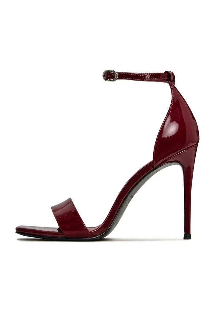 A pair of patent leather ankle-strap heels in classic red - a bold addition to any woman's high heel collection of fashion footwear.
