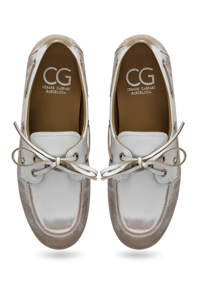 A close-up image of vintage leather loafers in a distressed white color, showcasing the classic style and worn-effect finish of these antique white footwear.