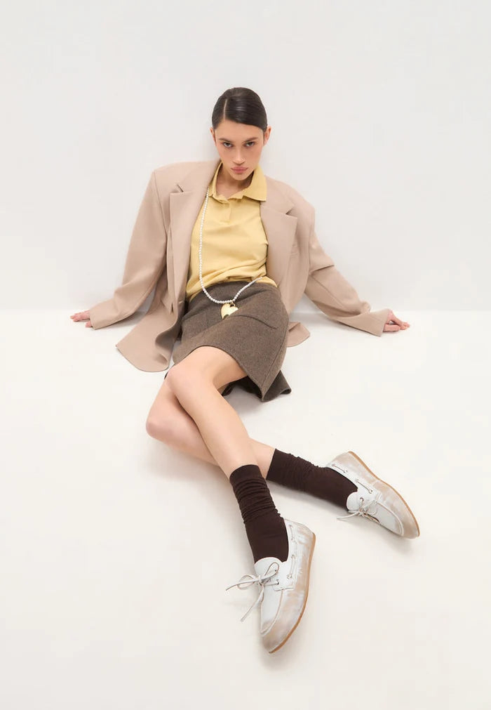 A stylish pair of vintage leather loafers in distressed white with a classic worn-effect, reminiscent of antique white footwear.