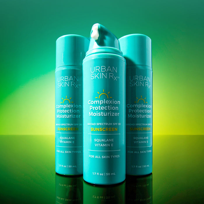 Three bottles of USRx Complexion Protection SPF30 Moisturizer on a bright green background