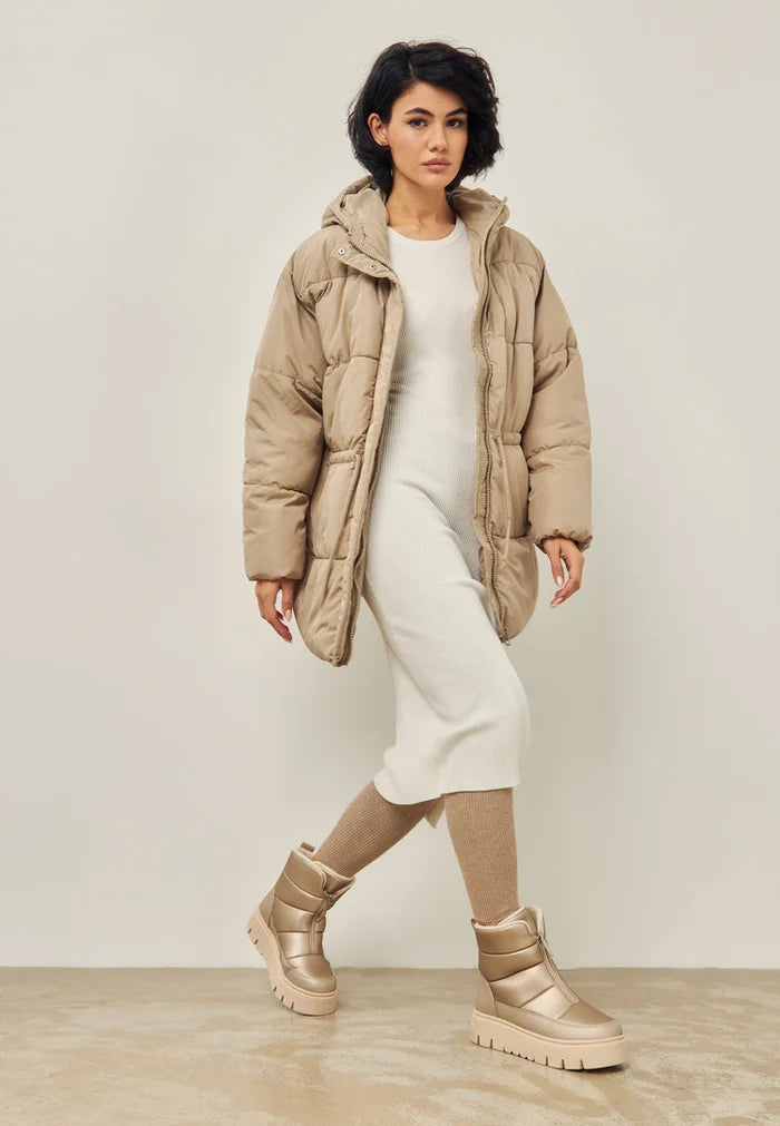 A pair of stylish beige winter boots perfect for snowy days, showcasing elegant and stylish cold weather footwear.