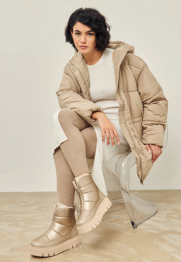 A pair of stylish beige winter boots, perfect for snowy weather and adding an elegant touch to your cold weather wardrobe.