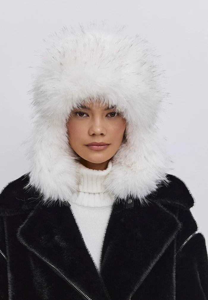 Woman wearing a stylish faux fur hat in black and white, perfect for winter fashion.
