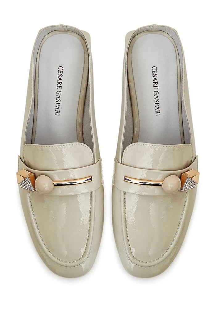 A pair of elegant white mules with a glossy charm, perfect for any stylish woman looking for trendy and sophisticated footwear.