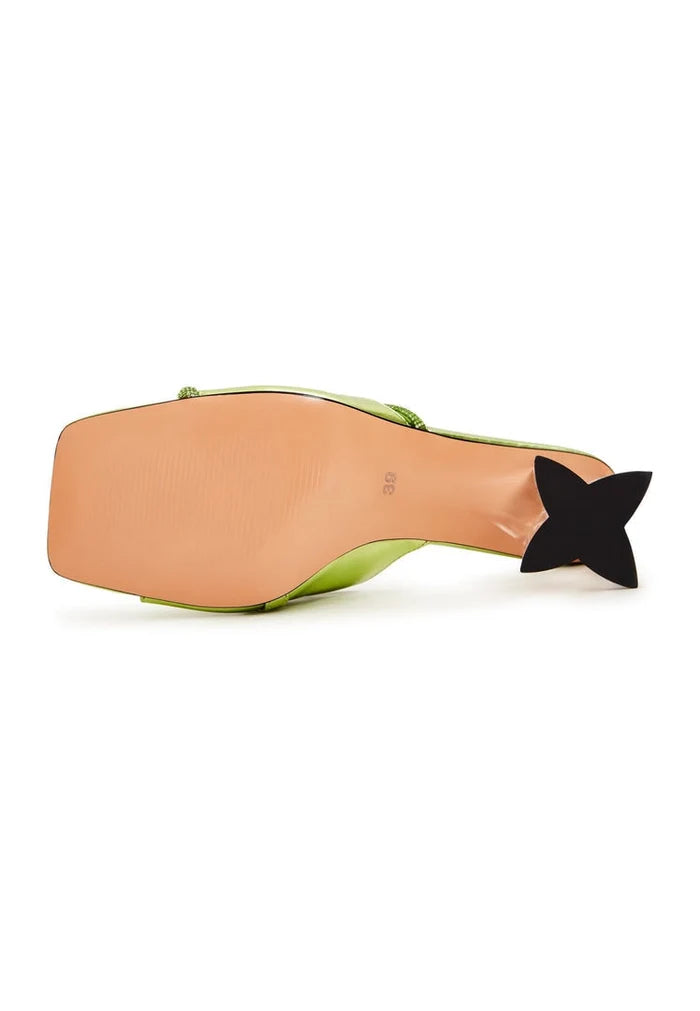A stylish pair of green block heel mules with star-shaped heels for women, portraying fashionable footwear.