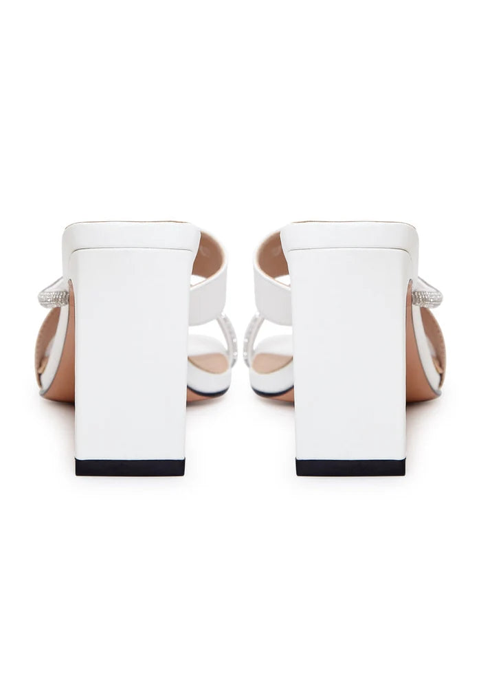 A pair of elegant white high heel sandals for women, featuring a strappy design perfect for any special occasion.