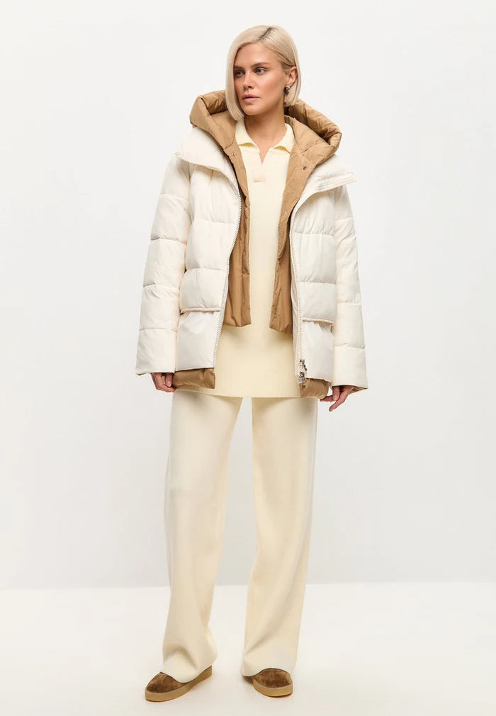 A stylish white hooded puffer jacket, perfect for staying warm and cozy in the winter snow. This chic outerwear fashion piece is a must-have for cold weather days.