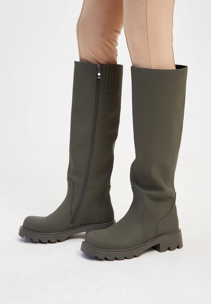 A pair of trendy green knee-high boots with chunky soles, perfect for women's fashion footwear.
