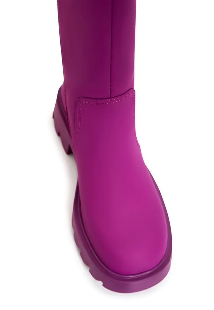 A trendy pair of women's knee-high pink boots with chunky soles, perfect for stylish fashion footwear enthusiasts.