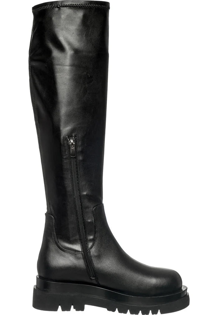 A stylish pair of women's knee-high leather lug boots, perfect for a fashionable and edgy look.