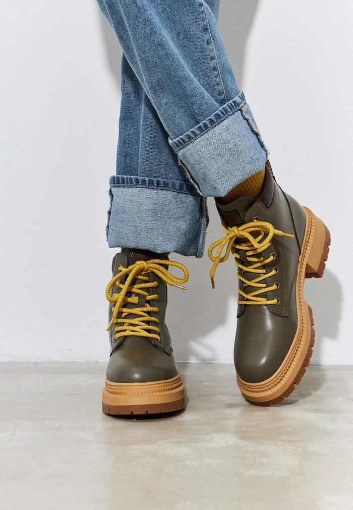 A stylish pair of trendy green lace-up ankle boots, perfect for fashion-forward women.