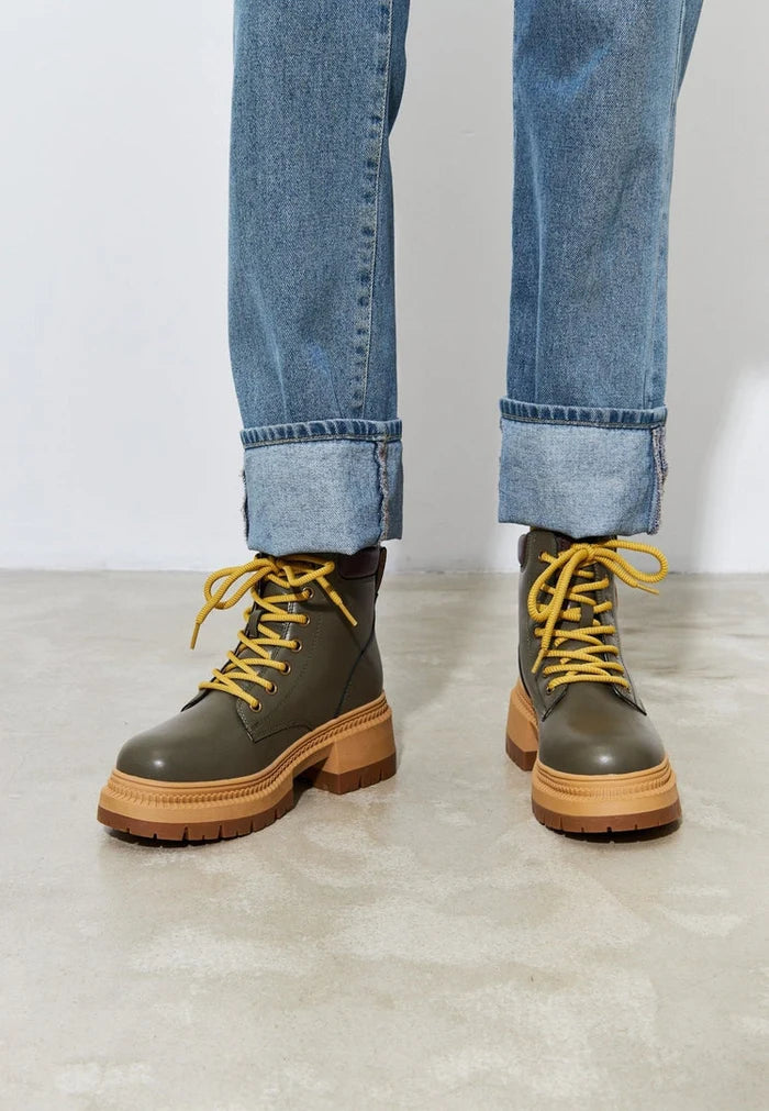 A stylish pair of trendy green lace-up ankle boots for women, perfect for a fashionable look.