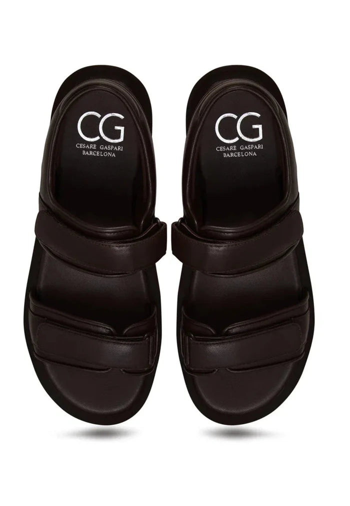 A stylish pair of women's dark brown leather sandals featuring a comfortable velcro closure design.
