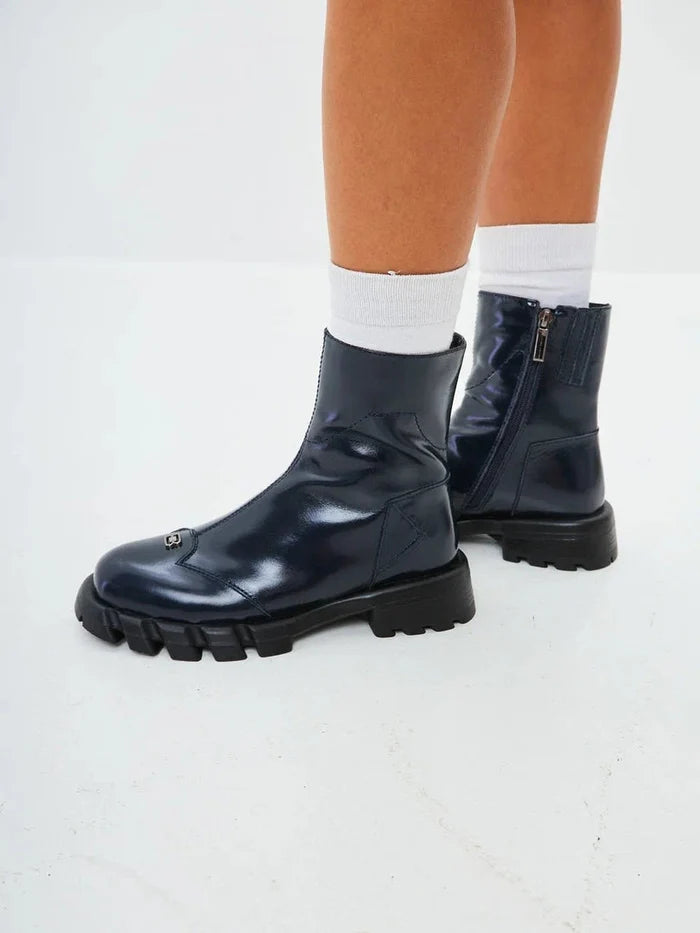 A stylish pair of blue leather ankle boots with a flat sole, perfect for women looking for trendy footwear.