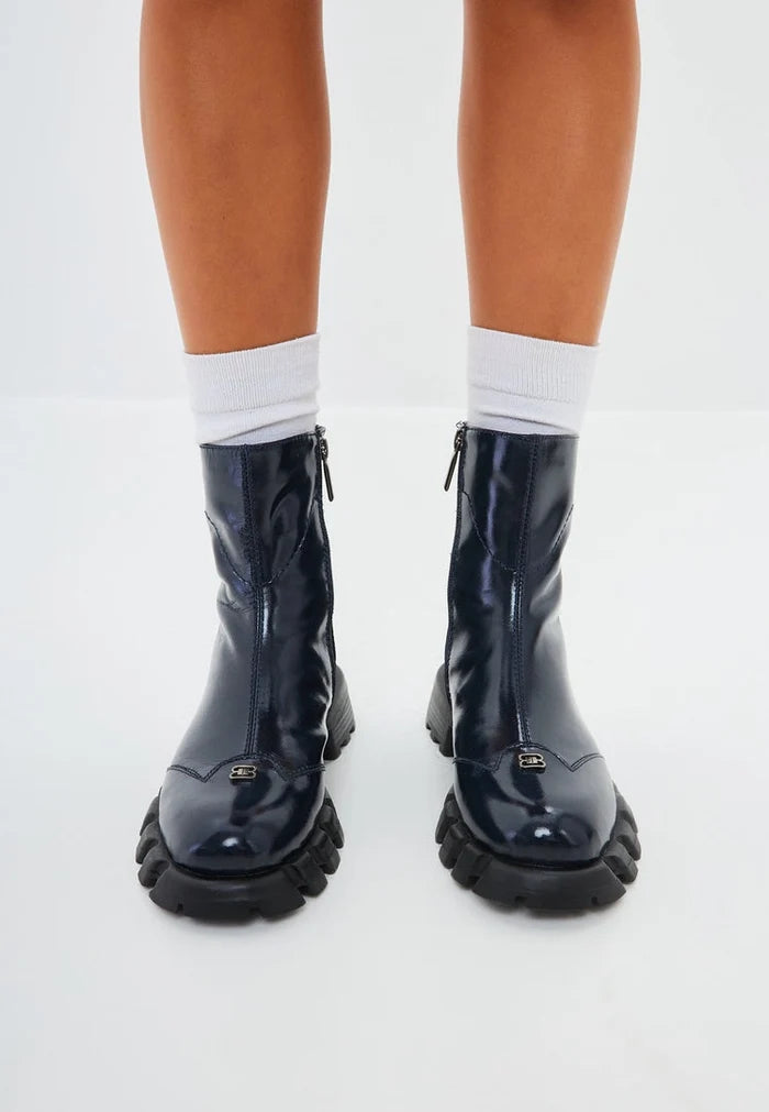 A stylish pair of blue leather ankle boots with a flat sole, perfect for trendy women's fashion.