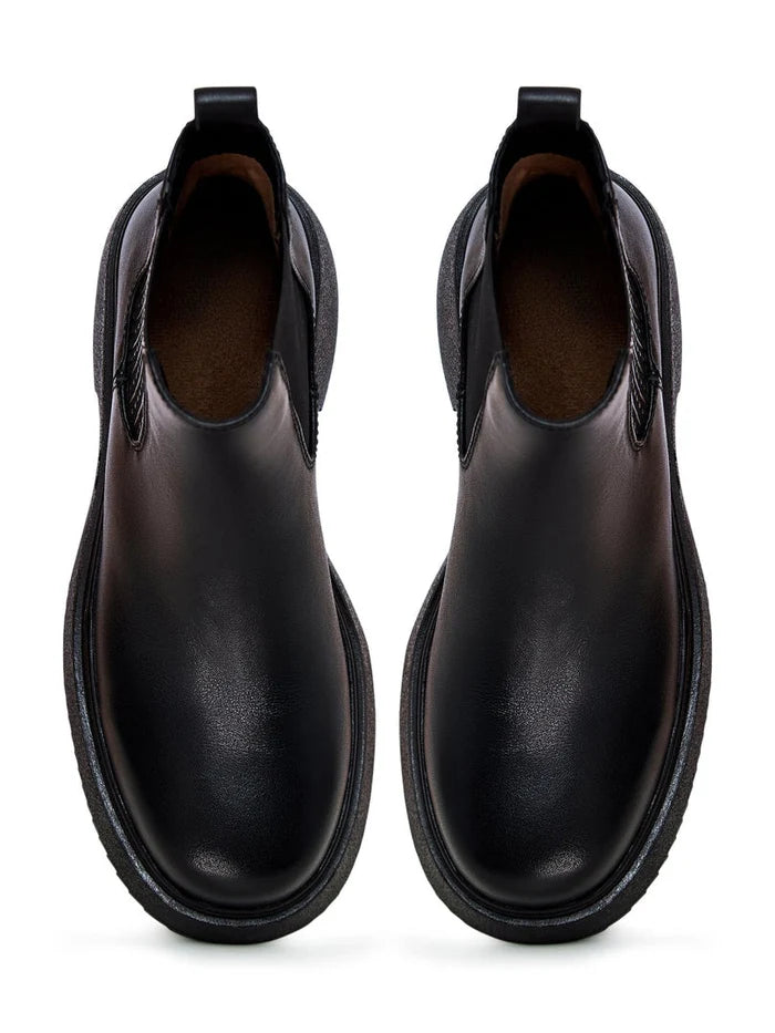 A fashionable pair of black leather platform ankle boots for women, featuring high heels perfect for a stylish and trendy look.