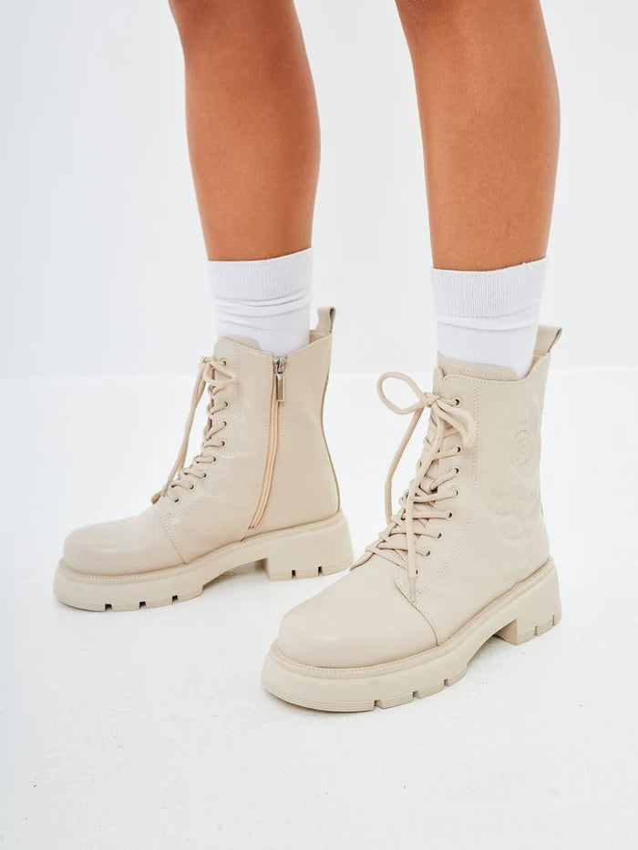 A pair of stylish leather platform ankle boots in ivory, perfect for women seeking high heel fashion.