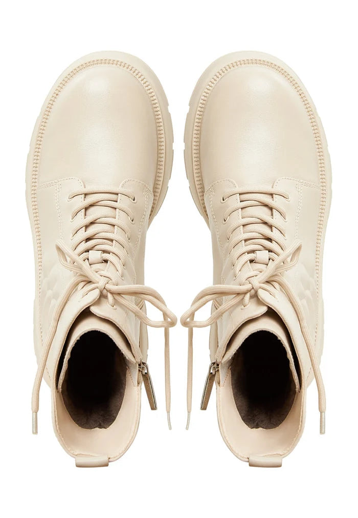 A close-up image of women's stylish leather platform ankle boots in ivory color with high heels.