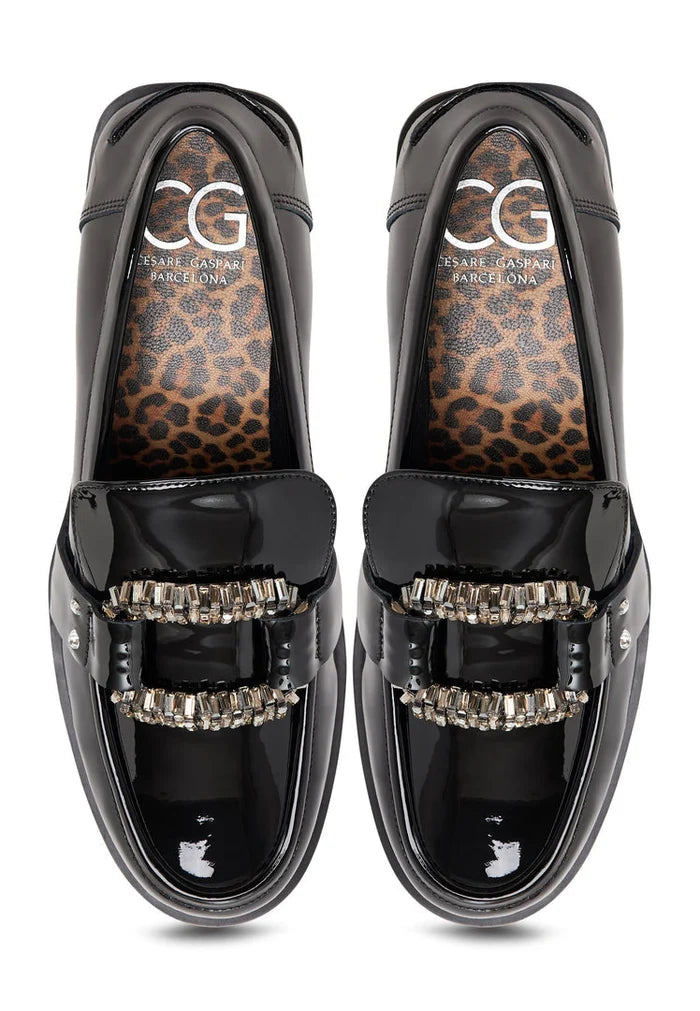 A close-up image of black patent loafers featuring crystal embellishments, also known as Bagheera loafers, making them the perfect black embellished shoes.