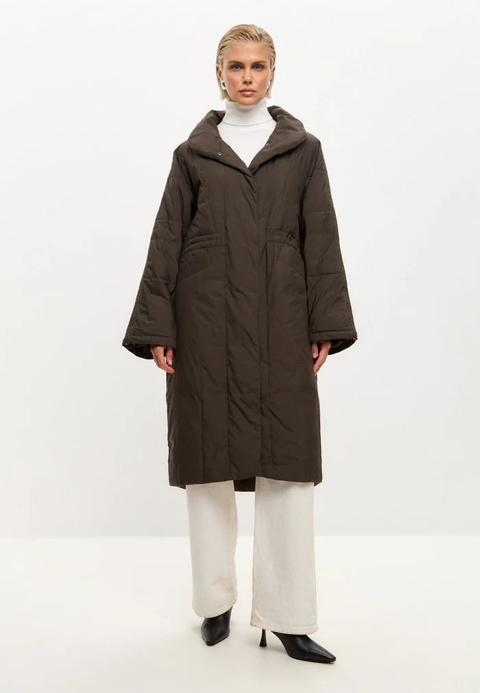 Stay warm and stylish with this fashionable long quilted coat in brown, the perfect women's quilted outerwear for winter.
