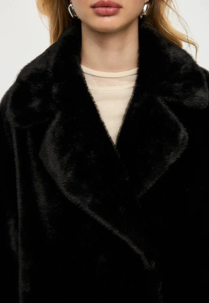 Stay warm and stylish this winter in the luxurious Freya faux fur coat. This black coat is the perfect addition to your winter fashion wardrobe.