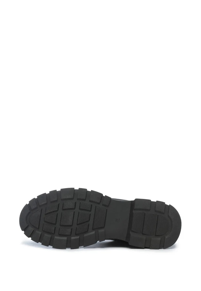 A close-up of black chunky sneakers with a cozy merino wool lining, perfect for keeping your feet warm and stylish.