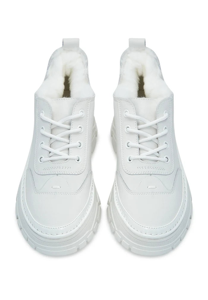 A close-up image showcasing stylish chunky white sneakers with a cozy merino wool lining, perfect for both fashion and comfort.