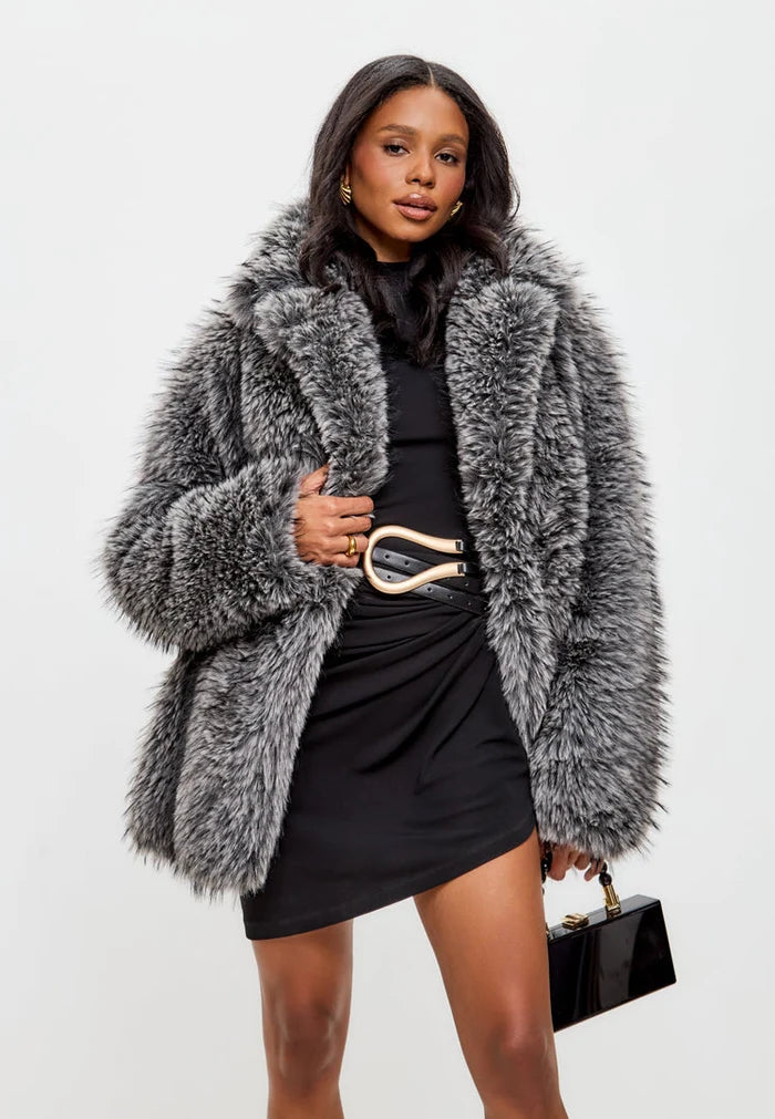A fashionable woman wearing an elegant grey faux fur coat, the perfect luxurious winter outerwear for women.