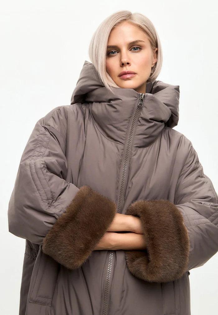 A stylish beige oversized hooded puffer coat with faux fur cuffs for women's winter fashion, perfect for staying warm in trendy outerwear.