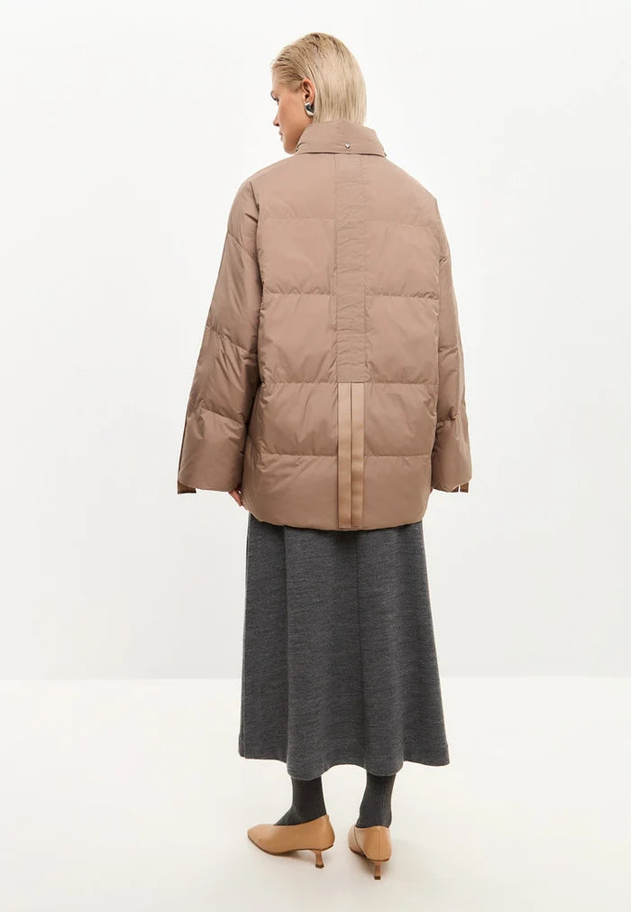 A stylish beige oversized quilted puffer jacket, the perfect fashionable winter outerwear.