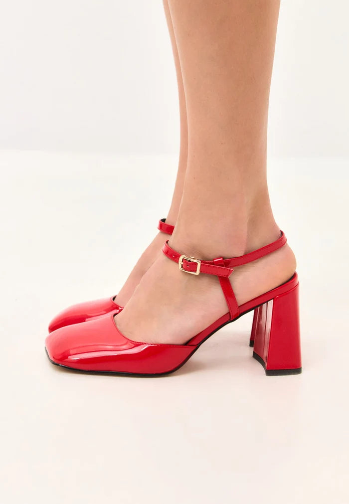 A pair of stylish red patent block heel pumps in glossy patent leather, perfect for adding a pop of color to any outfit.