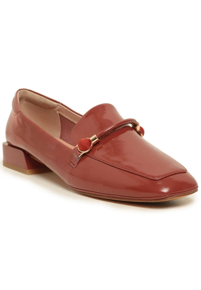 A fashionable pair of orange patent leather loafers with metallic accents, perfect leather slip-on shoes for a trendy look.