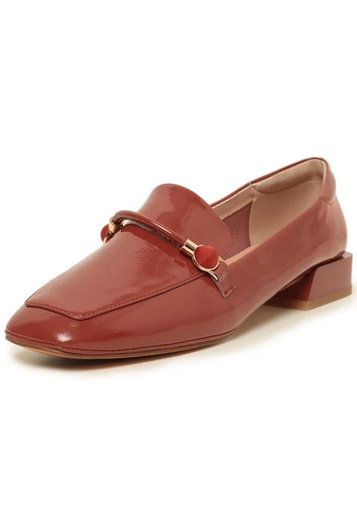 A stylish pair of patent leather loafers with metallic accents in orange, perfect for adding a pop of color to your wardrobe. These leather slip-on shoes are on-trend fashion loafers that are sure to make a statement.