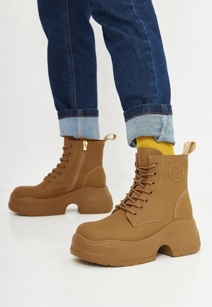 A stylish pair of beige platform ankle boots for women, perfect for adding a touch of fashion-forward flair to any outfit.