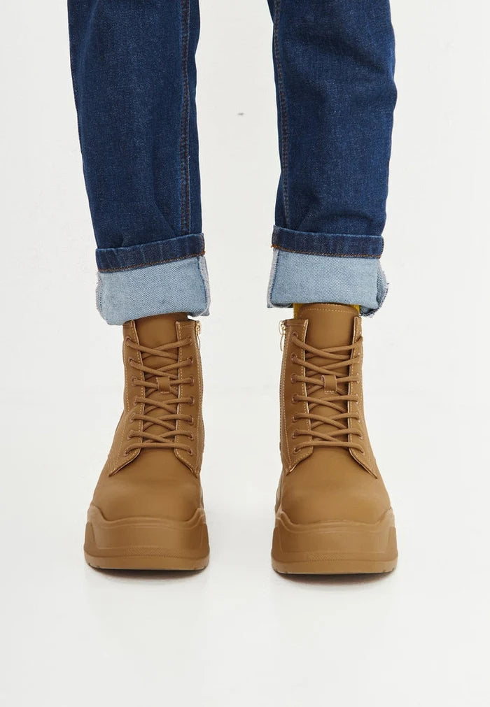A stylish pair of women's beige platform ankle boots, the perfect fashion boots for the season, showcasing designer footwear elegance.