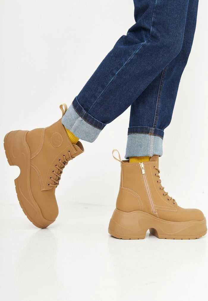A stylish pair of beige platform ankle boots for women, perfect for your fashion-forward wardrobe. These designer footwear are a must-have for any fashionista.