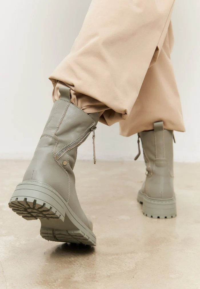 A trendy pair of green leather platform boots for women, perfect as fashionable footwear!