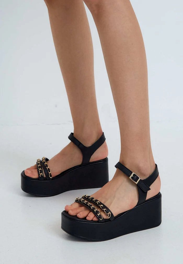 A chic pair of black platform sandals with gold chain accents, perfect for all women's fashion-forward footwear looks.