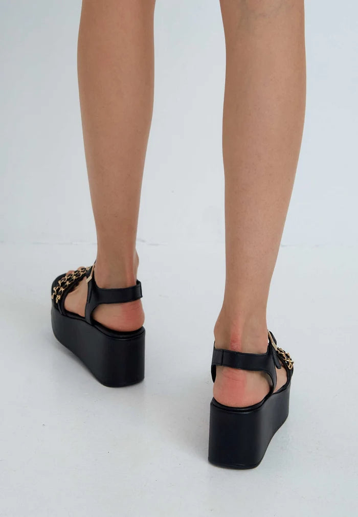 A stylish pair of black platform sandals for women featuring trendy gold chain accents, perfect for any fashionable shoe lover.
